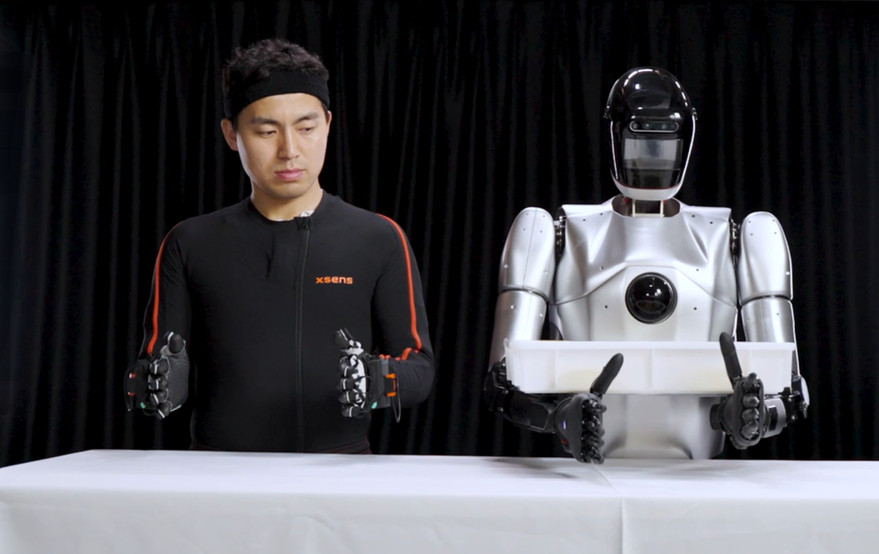 man in Xsens suit teleoperates robot